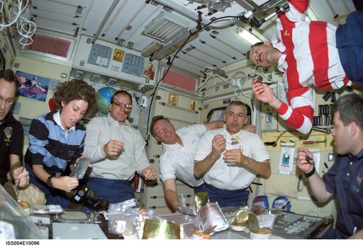 STS-110 and Expedition Four crewmembers gather for a meal in the Zvezda SM