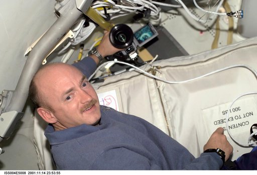 Mark Kelly poses for the camera in the ISS during STS-108, Expedition Four