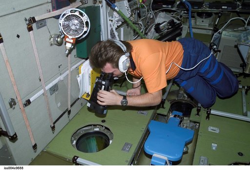 Onufrienko uses binoculars to look out SM window during Expedition Four
