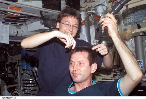 Whitson cuts Treschev's hair in the SM during Expedition Five on the ISS