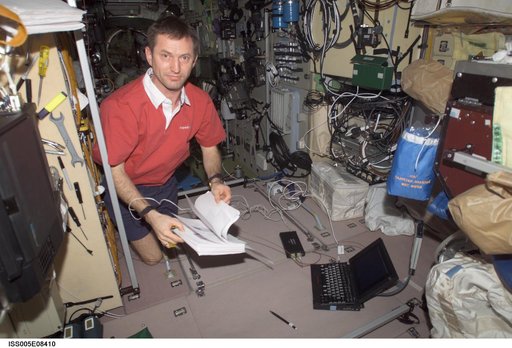 Treschev thumbs through manual in the SM taken during Expedition Five on the ISS
