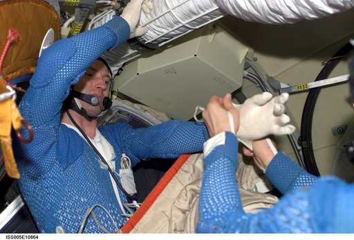 Korzun helps Treschev with his LCVG in the Pirs Docking Compartment during Expedition Five