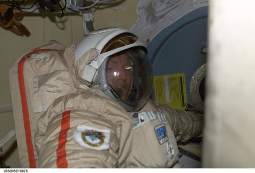Treschev attired in his Russian EVA Orlan suit prepares for an EVA in the Pirs Docking Compartment