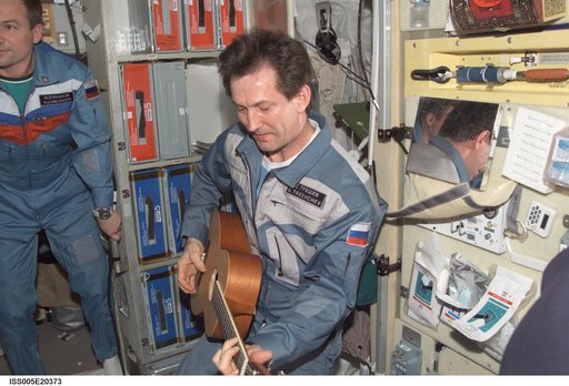 Treschev plays guitar in the SM during Expedition Five on the ISS