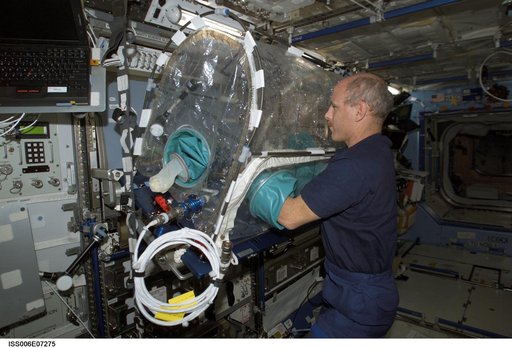 Expedition Six Commander Bowersox works with an experiment in a portable glovebox facility