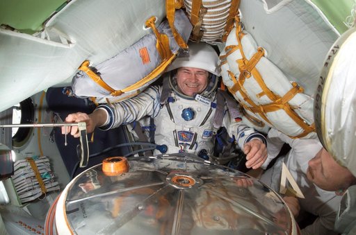 Budarin conducts a fit check of his Kazbek seat in the Soyuz during Expedition Six