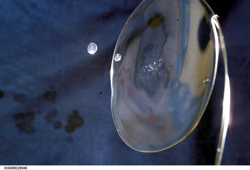 View of a surface tension demonstration using water that is being held in place by a 50mm metal loop