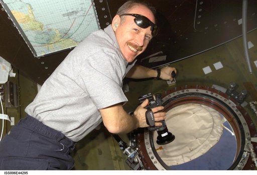 Commander Kenneth D. Bowersox poses for image as he holds digital camera in the U.S. Laboratory