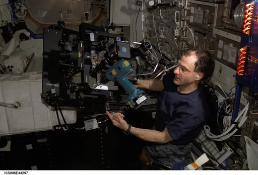 Pettit looks through a spotting scope and runs a drill at the same time in the U.S. Laboratory