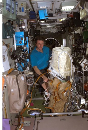 Foale poses beside the Expedition 8 EVA bundle in the SM
