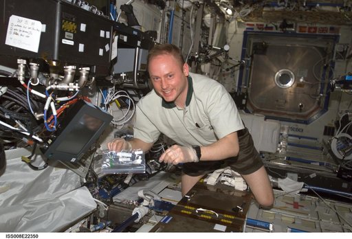 Fincke holds an ammonia test strip while working in the U.S. Laboratory during EXP 9 / EXP 8