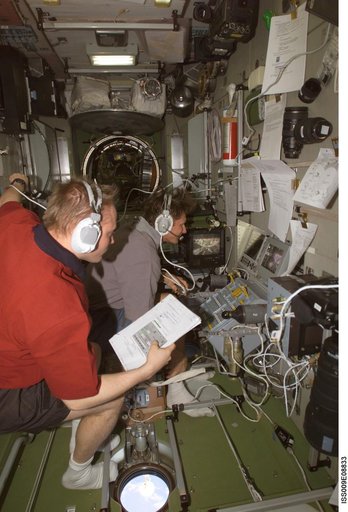 Fincke reads a checklist as he watches Padalka at the Simvol-Ts workstation during Progress 14P docking approach OPS on Expedition 9