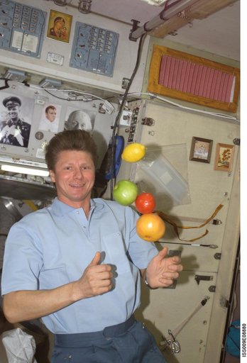 Padalka watches as fruit floats in the Service Module during Expedition 9