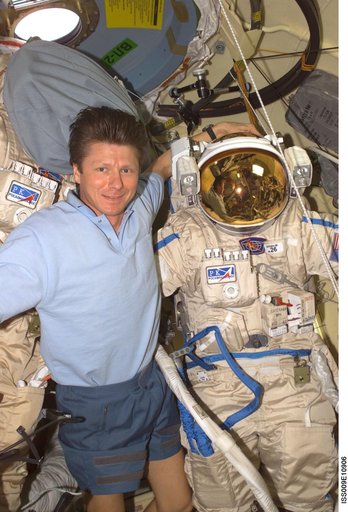 Padalka poses with an Orlan EVA suit during checkout operations on Expedition 9
