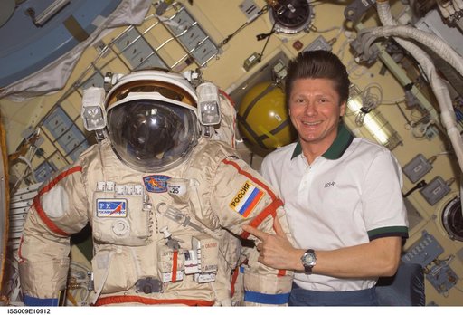 Padalka poses with an Orlan EVA suit inside the Pirs DC during Expedition 9
