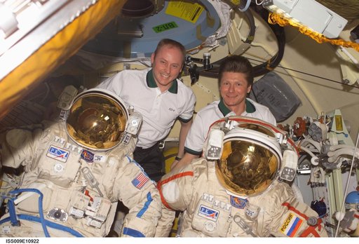 Fincke and Padalka pose with their Orlan EVA suits inside the Pirs DC during Expedition 9