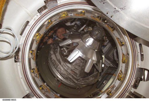 Fincke inside the Progress Vehicle with open SM/Progress transfer hatch during Expedition 9