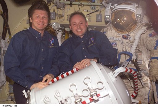 Padalka and Fincke pose with Orlan suit in the Pirs Docking Compartment during Expedition 9