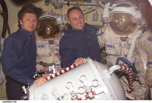 Padalka and Fincke pose with Orlan suit in the Pirs Docking Compartment during Expedition 9