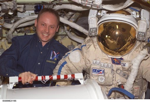 Padalka and Fincke pose with Orlan suit in the Pirs Docking Compartment during Expedition 9
