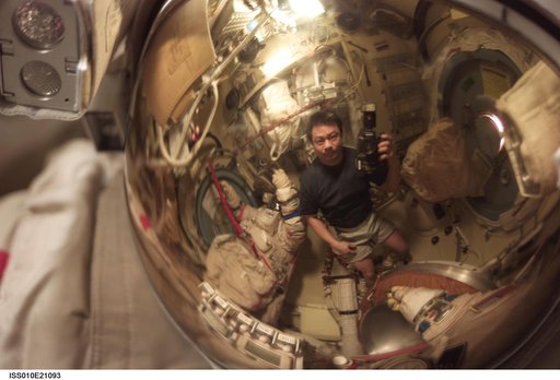Chiao appears as a small reflection in a helmet visor in the Pirs DC1