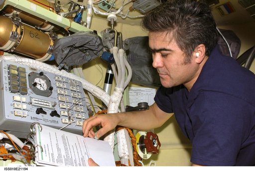 Sharipov reads manual at the Russian Orlan Interface Unit in the Pirs DC1 during Expedition 10