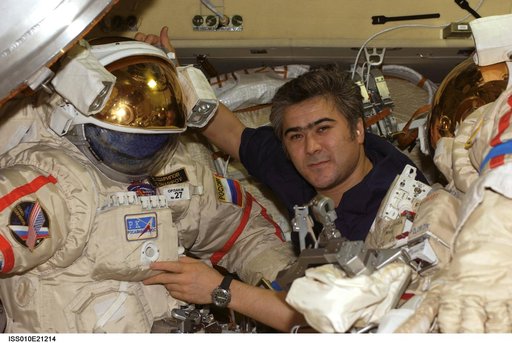 Sharipov poses with Russian Orlan suits in the Pirs DC1 during Expedition 10