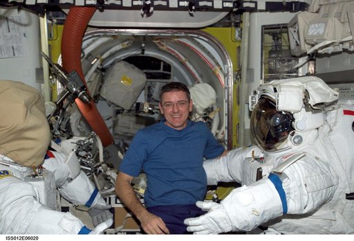 McArthur posses with EMUs inside the Airlock during Expedition 12