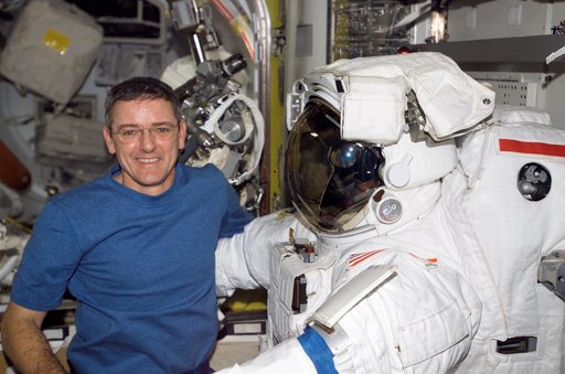 McArthur posses with EMU inside the Airlock during Expedition 12