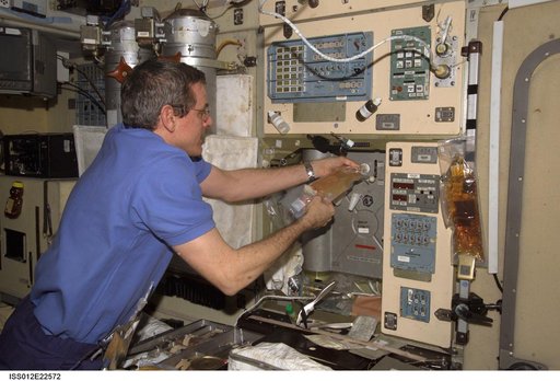 McArthur hydrates a juice drink using the potable water heater on Expedition 12