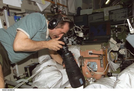 Vinogradov photographs at window in the SM during Expedition 13