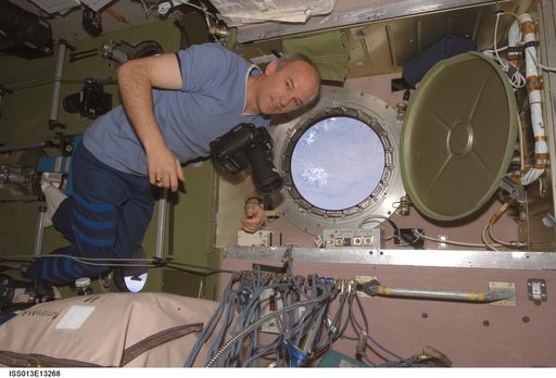 Williams prepares to take pictures at the SM window during Expedition 13