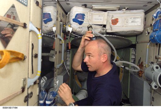 Williams cuts his hair in the SM during Expedition 13