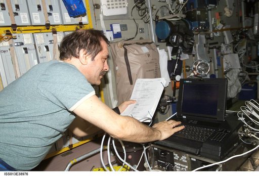 Vinogradov looks at manual in the SM during Expedition 13