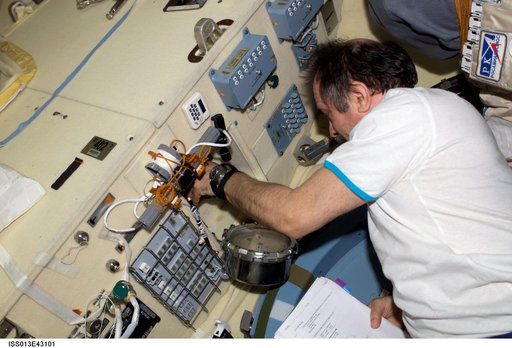 Vinogradov works with pressure equalization/depress valves in the Pirs DC1 during Expedition 13