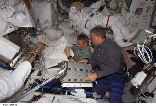 Reiter and Lindsey works in the Quest Airlock during Expedition 13 / STS-121 Joint Operations