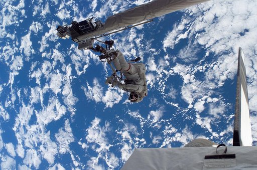 Sellers anchored to the Space Shuttle Discoverys RMS OBSS foot restraint during STS-121 EVA