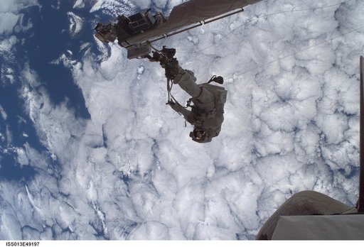 Sellers anchored to the Space Shuttle Discoverys RMS OBSS foot restraint during STS-121 EVA
