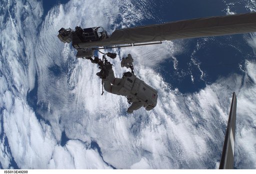Sellers anchored to the Space Shuttle Discoverys RMS OBSS foot restraint during STS-121 EVA