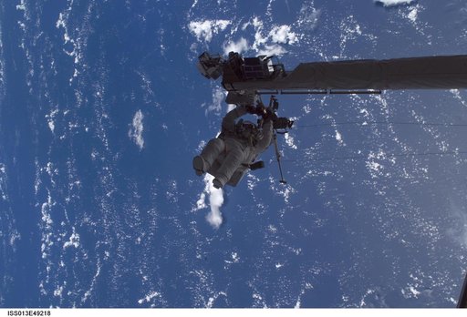 Sellers anchored to the Space Shuttle Discoverys RMS OBSS foot restraint during STS-121 EVA