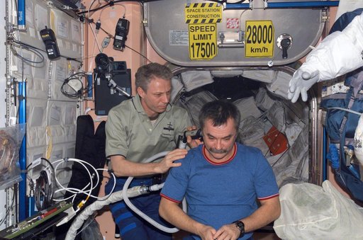 Reiter cuts Tyurins hair in the Zvezda Service module