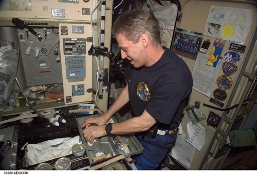 Reiter with food cans in galley area of Zvezda Service module