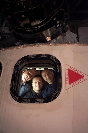 STS-116 crew at orbiter aft flight deck window during EVA 2