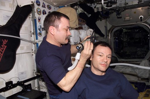 Tyurin gives Lopez-Alegria a hair cut in Node 1 module