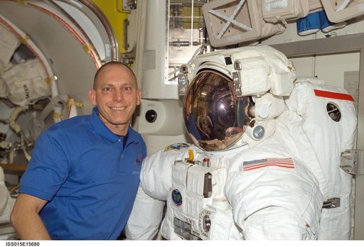 View of Anderson posing with an EMU in the A/L during Expedition 15