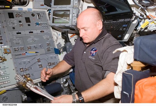 Kelly looks over crew procedures in the aft FD on Space Shuttle Endeavor during Joint Operations