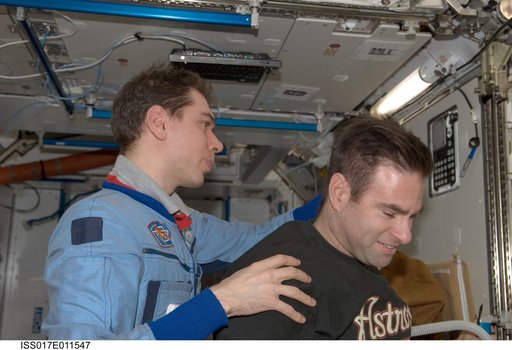 Volkov gives Chamitoff a haircut in the Node 2 during Expedition 17