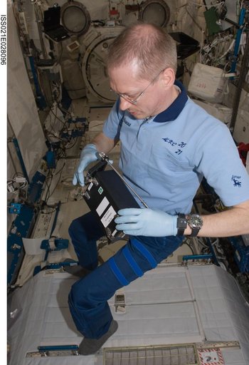 Commander De Winne works on the RadSilk Experiment in the JPM
