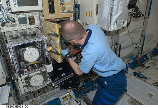 Commander De Winne works on the RadSilk Experiment in the JPM