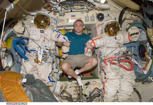 Suraev poses with Orlan-MK Suits in the Pirs DC-1 during Expedition 22